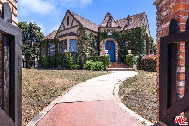 a front view of a house with a yard and potted plants