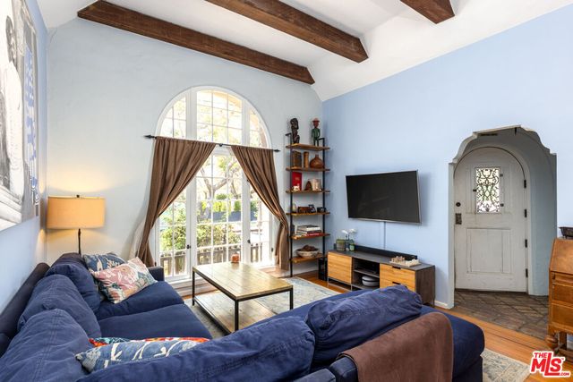 a living room with furniture a flat screen tv and a large window