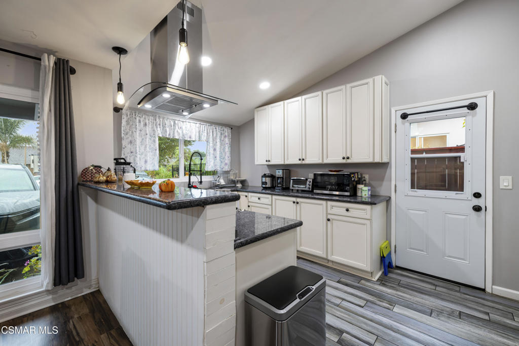 1231 Bluebell Street Oxnard, CA 93036 - Photo 8 of 44 a kitchen with kitchen island granite countertop a stove cabinets and wooden floor