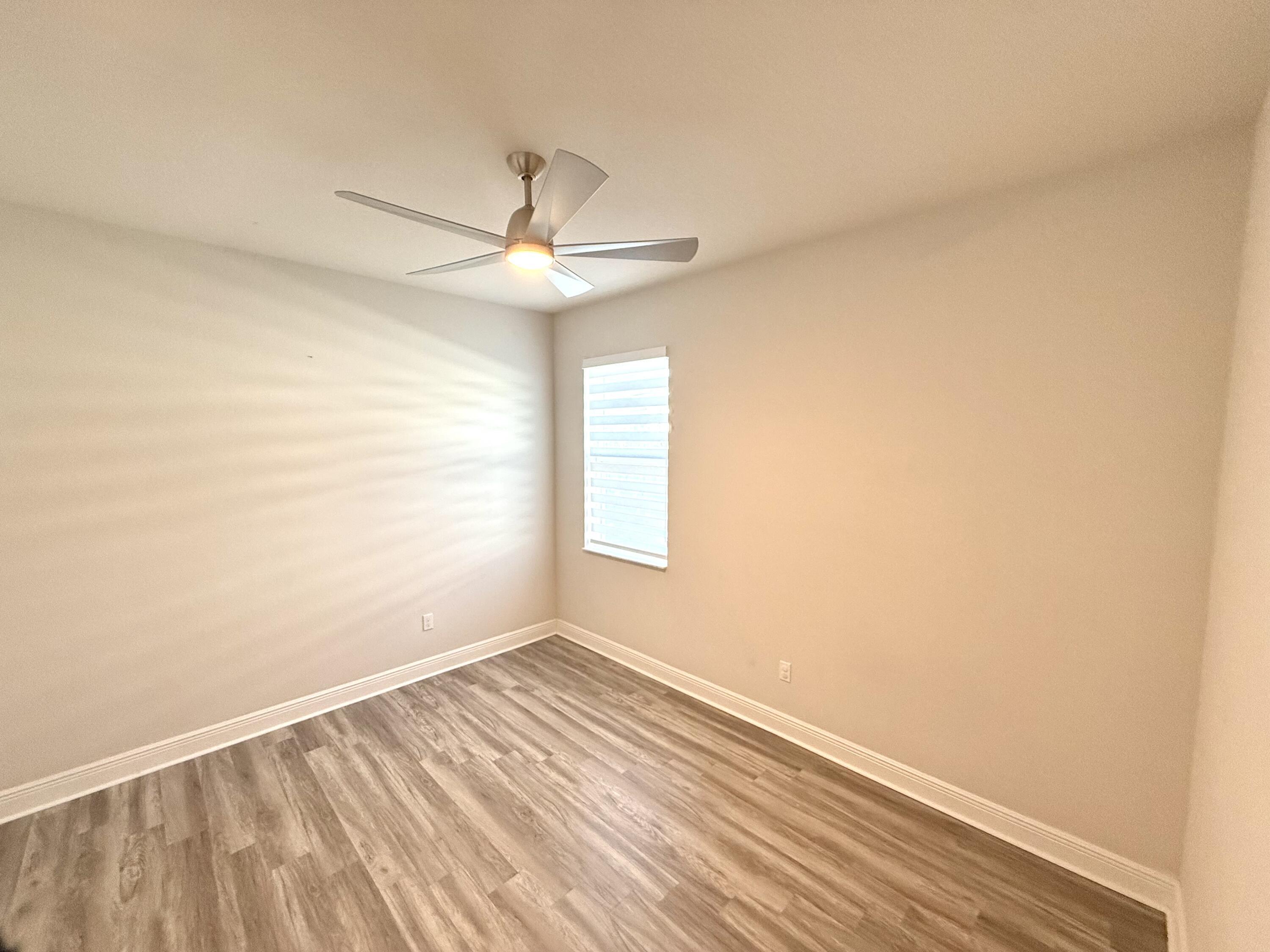 10819 Southwest Pacini Way Port St. Lucie, FL 34987 - Photo 18 of 43 an empty room with a window and a ceiling fan
