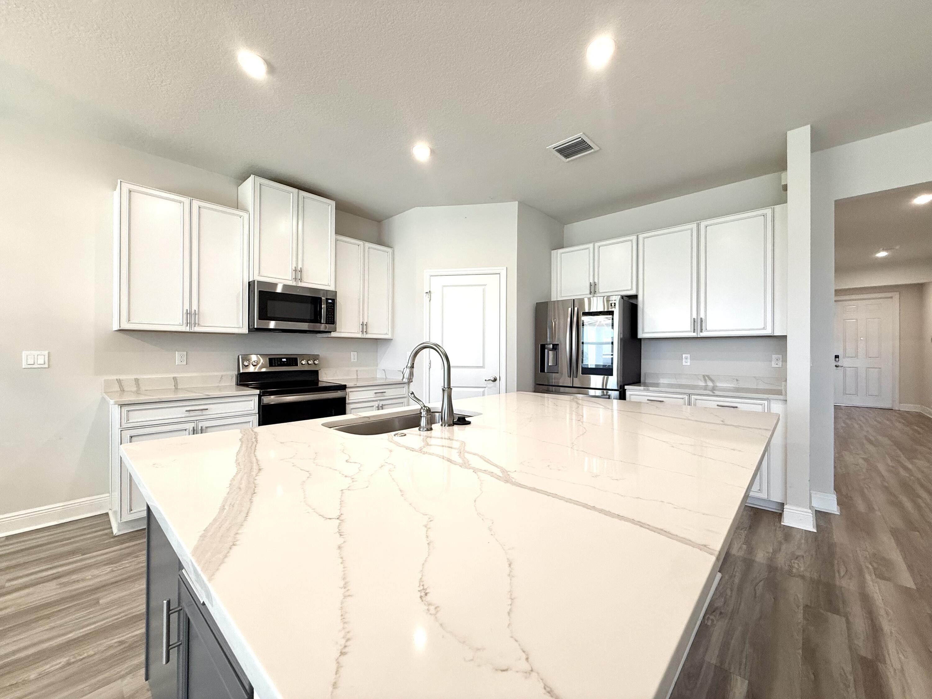 10819 Southwest Pacini Way Port St. Lucie, FL 34987 - Photo 19 of 43 a kitchen with stainless steel appliances a refrigerator sink stove microwave and cabinets