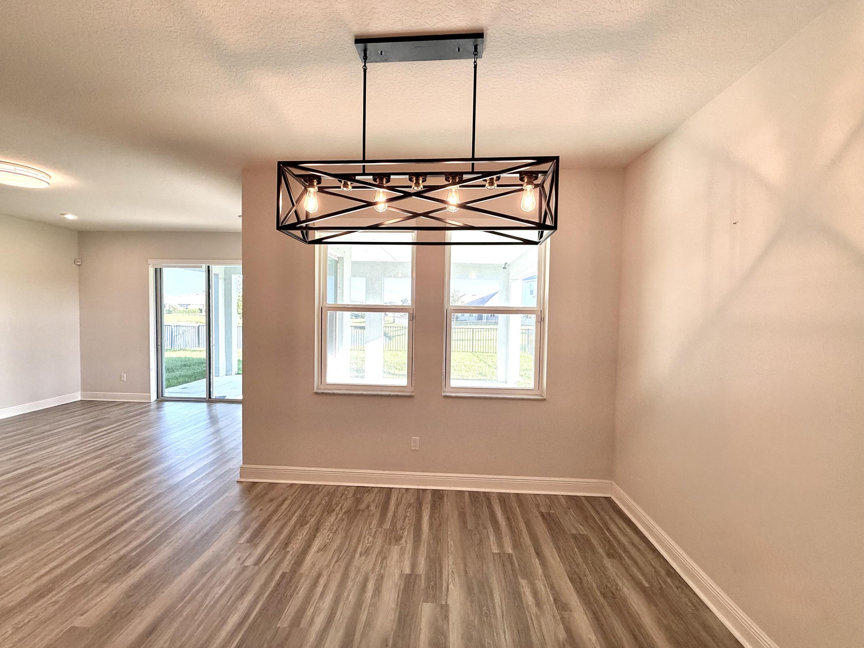 10819 Southwest Pacini Way Port St. Lucie, FL 34987 - Photo 21 of 43 an empty room with wooden floor and windows