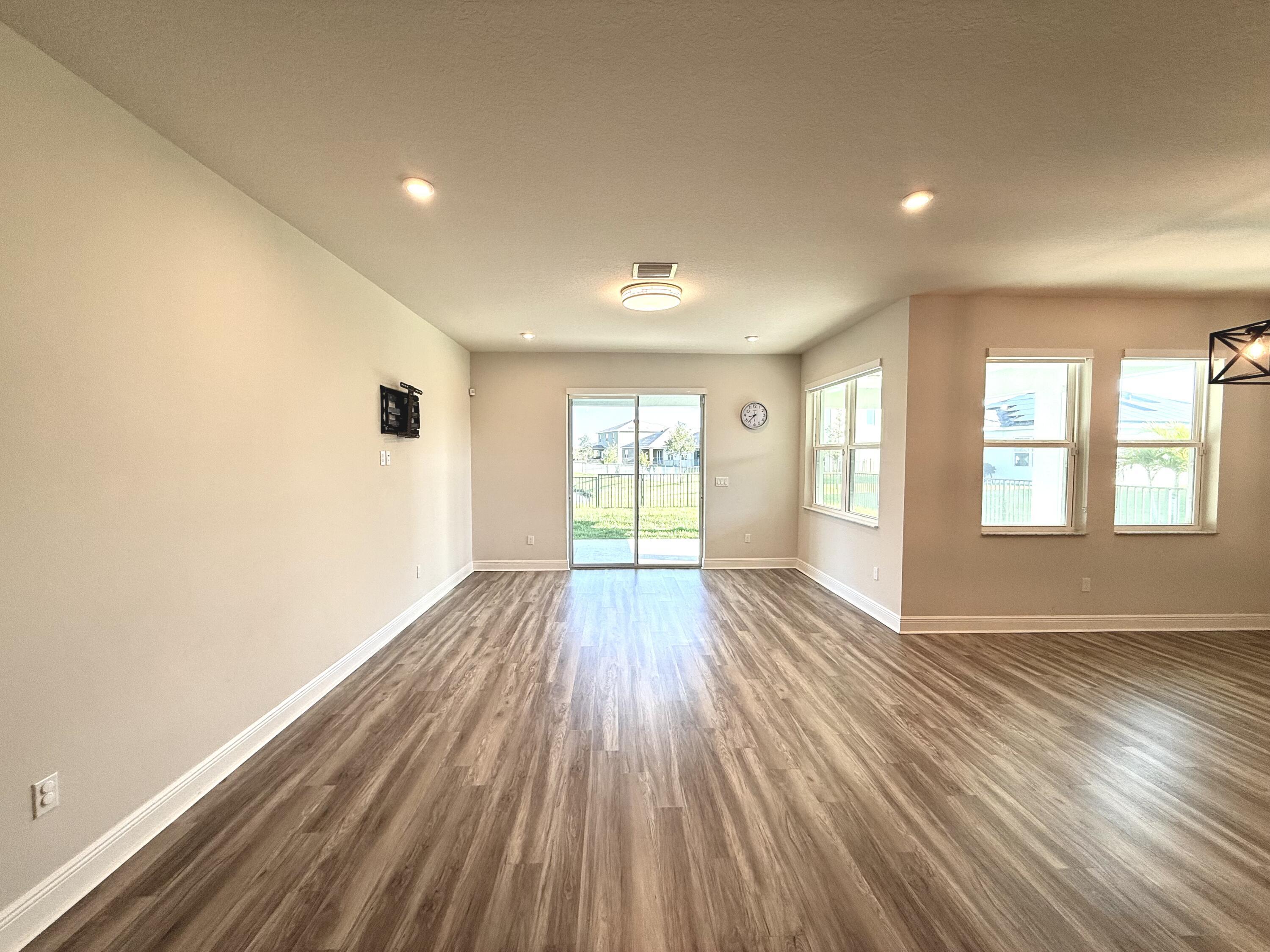 10819 Southwest Pacini Way Port St. Lucie, FL 34987 - Photo 22 of 43 an empty room with wooden floor and windows