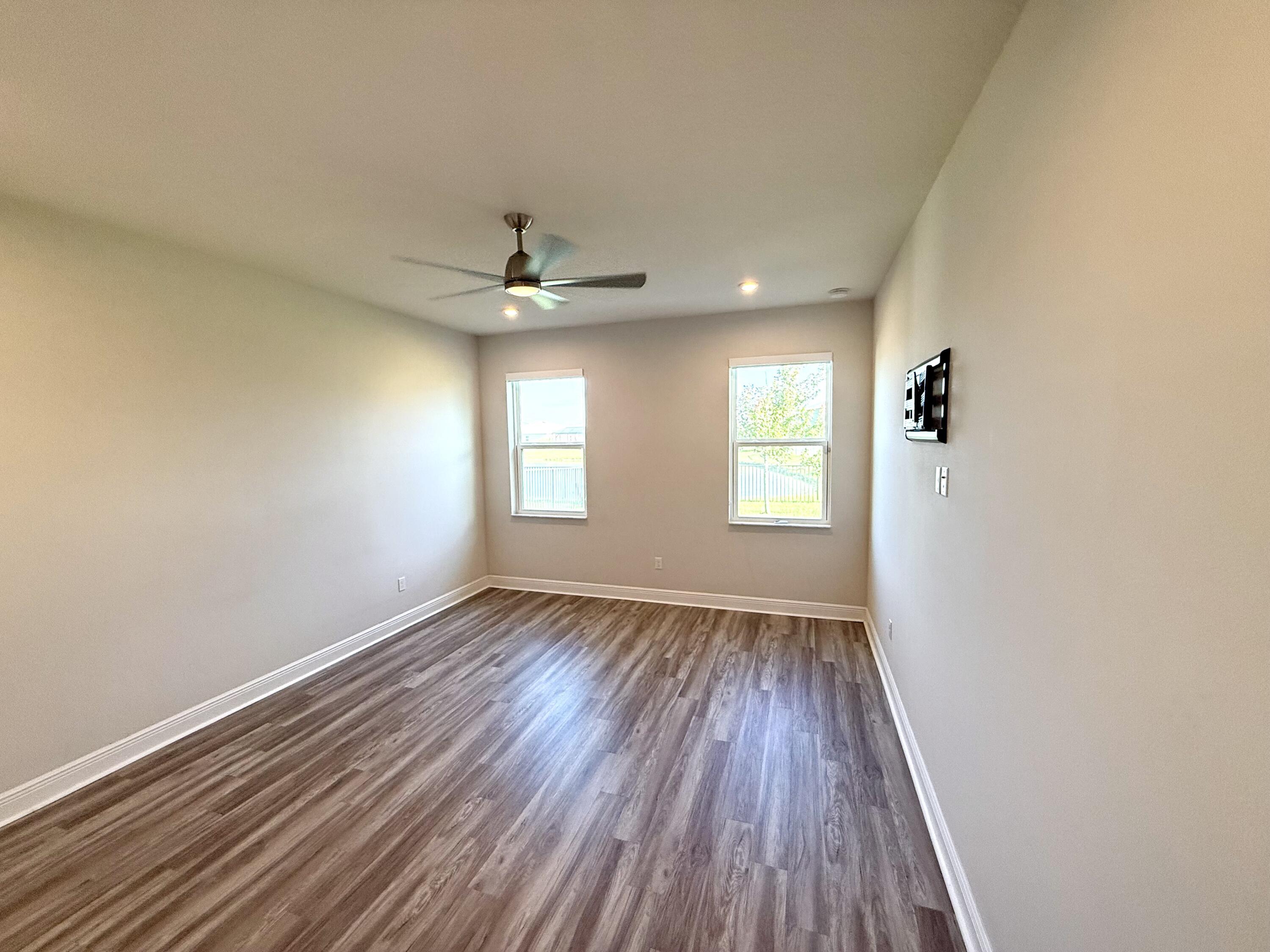 10819 Southwest Pacini Way Port St. Lucie, FL 34987 - Photo 24 of 43 wooden floor in an empty room with a window