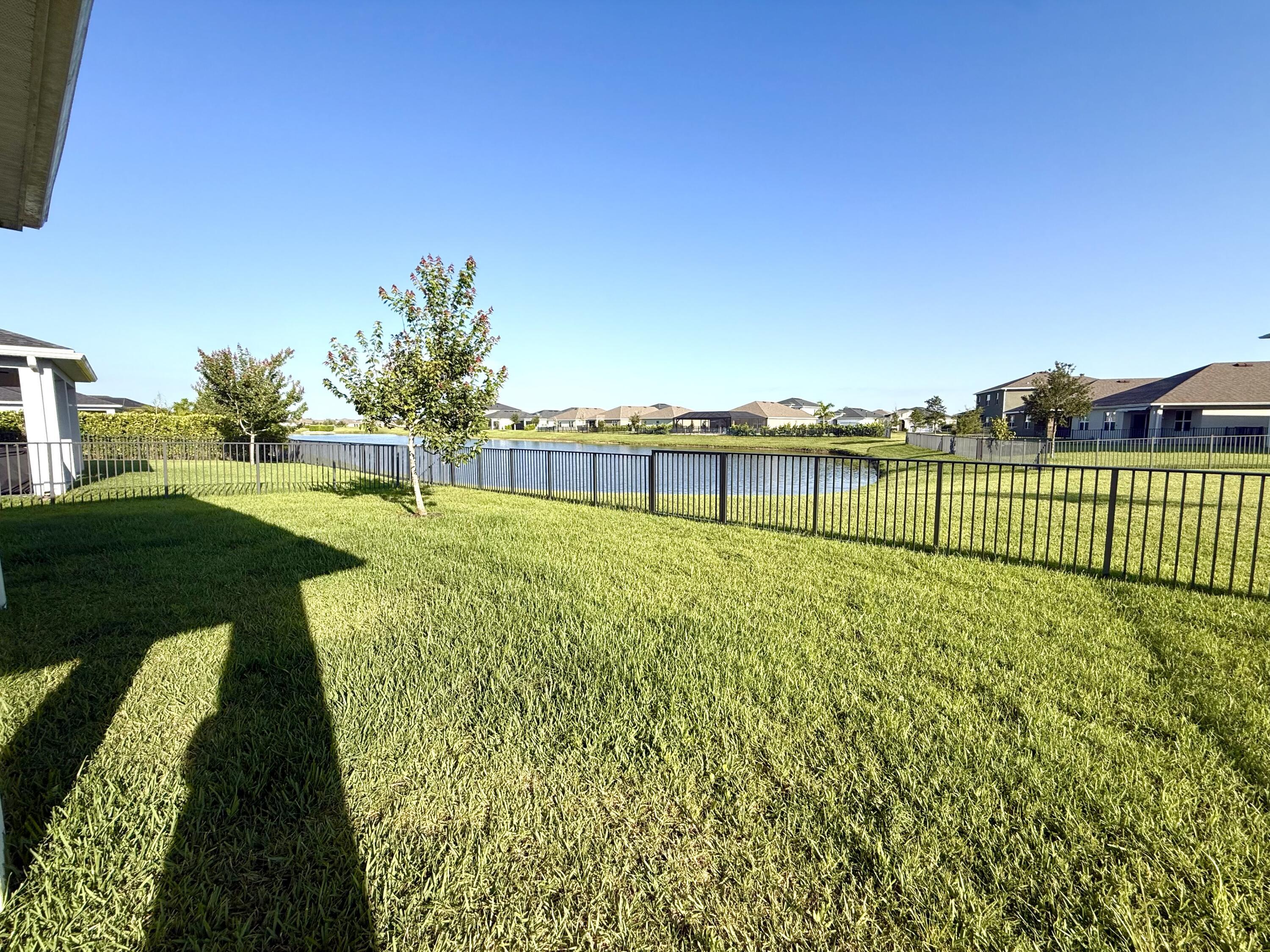 10819 Southwest Pacini Way Port St. Lucie, FL 34987 - Photo 30 of 43 a view of a garden with a bench in the background