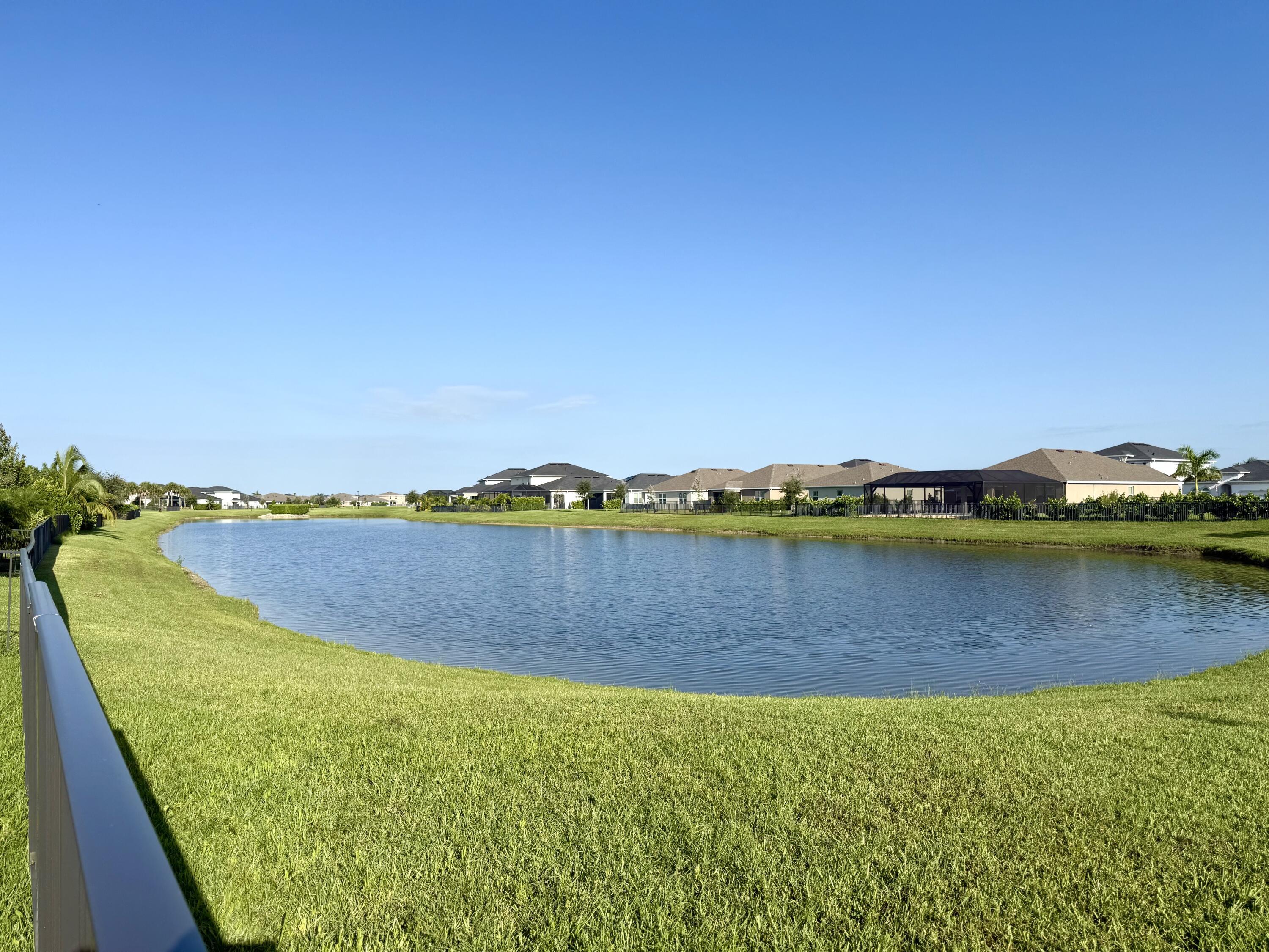 10819 Southwest Pacini Way Port St. Lucie, FL 34987 - Photo 31 of 43 a view of a lake with a houses in the background