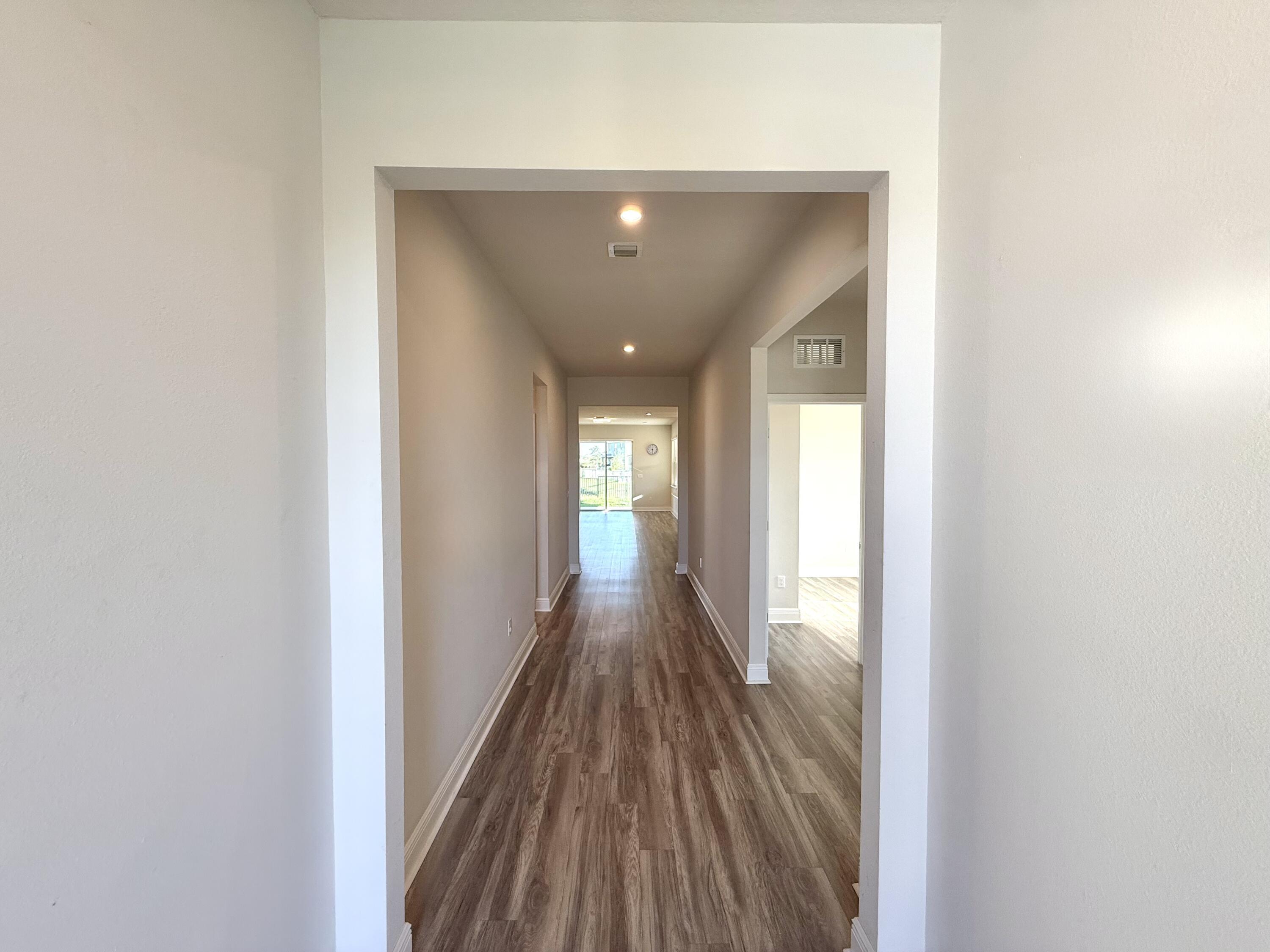 10819 Southwest Pacini Way Port St. Lucie, FL 34987 - Photo 10 of 43 a view of a hallway with wooden floor and staircase