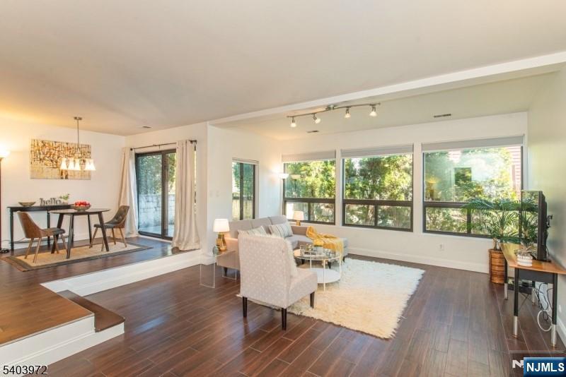 a living room with furniture and a large window with wooden floor