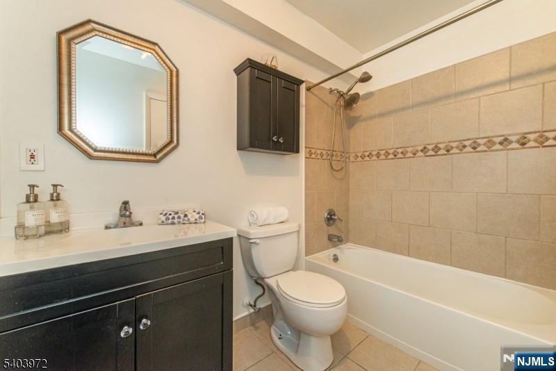 105 River Road, Unit C1 Nutley, NJ 07110 - Photo 17 of 22 a bathroom with a toilet a sink a tub and mirror