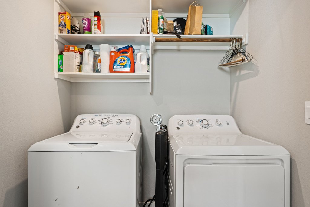 7403 Travertine Spring Drive, Unit 117 Austin, TX 78744 - Photo 28 of 37 Functional laundry space includes convenient shelving and a clothes rod for everyday ease.