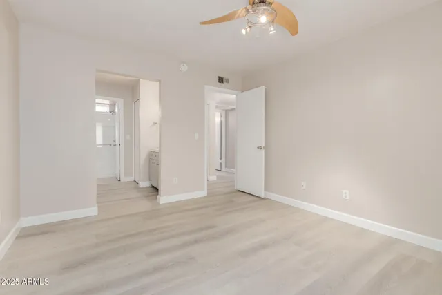 an empty room with fan and entrance