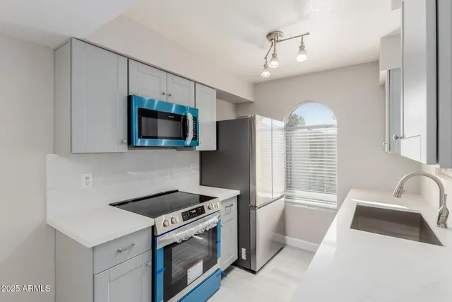 a kitchen with stainless steel appliances a stove a sink and a microwave