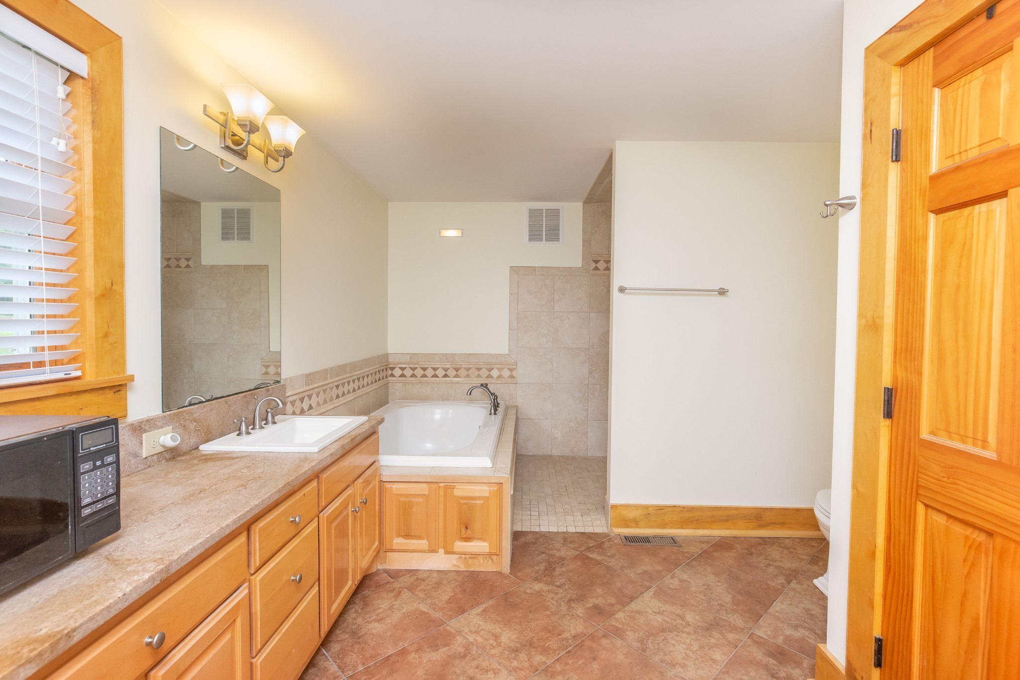 521 Coop Road Bell Buckle, TN 37020 - Photo 52 of 63 a spacious bathroom with a granite countertop sink and a mirror