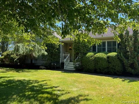 312 Riley Avenue Calverton, NY 11933 - Photo 10 of 30 Ranch-style exterior featuring horizontal siding, dark shutters, manicured landscaping, and a front porch with white railings