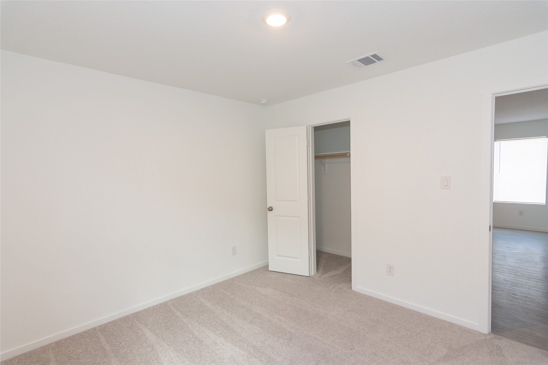 153 Star Packer Lane Jarrell, TX 76537 - Photo 19 of 30 A well-lit, neutral-toned room features plush carpeting and a convenient closet space.