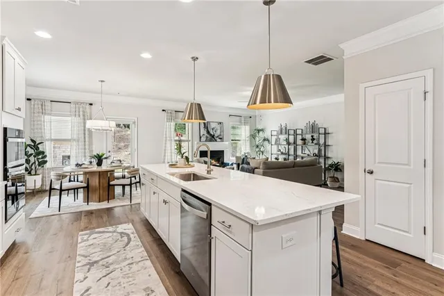 a large kitchen with kitchen island a stove a sink a center island and a wooden floor