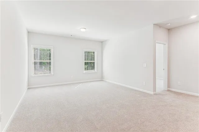 an empty room with windows and ceiling fan