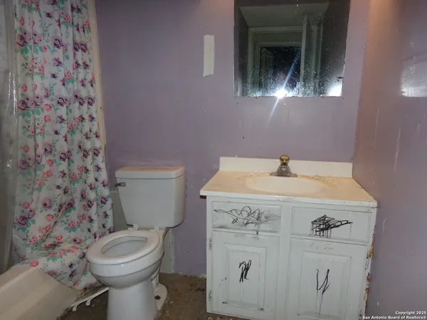 a bathroom with a sink a toilet and a mirror