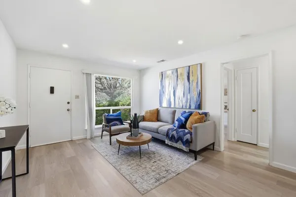 a living room with furniture and a wooden floor