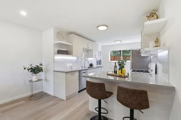 a kitchen with granite countertop a sink cabinets and stainless steel appliances
