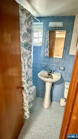 a bathroom with a sink a toilet and mirror