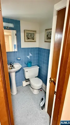 a white toilet sitting next to a sink and a mirror