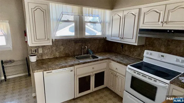 a kitchen with granite countertop white cabinets and white appliances