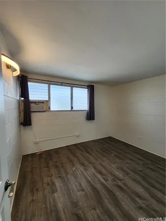 a view of a livingroom with wooden floor and a window