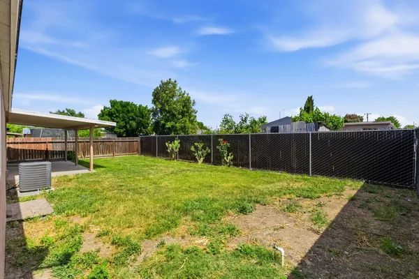 a view of backyard with wooden fence