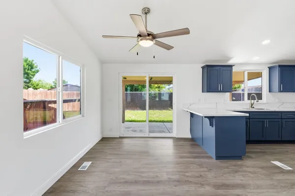 a kitchen with kitchen island a sink wooden floor and a large window