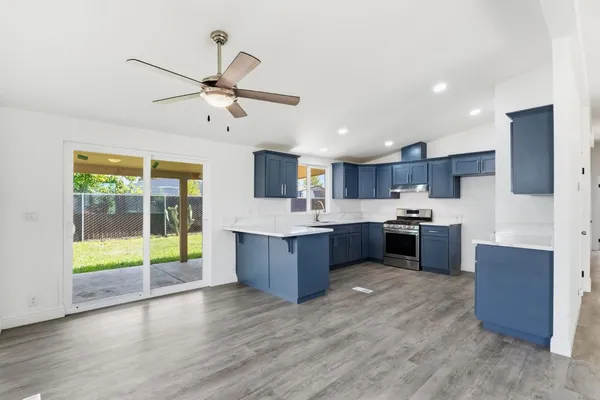 a large kitchen with stainless steel appliances wooden floors and wooden cabinets