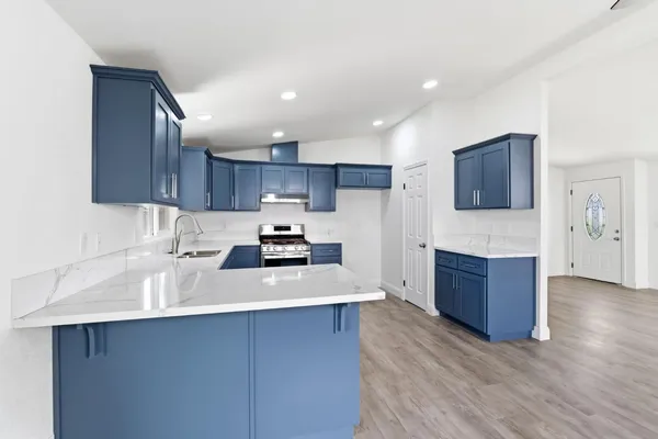 a kitchen with stainless steel appliances granite countertop a sink stove and refrigerator