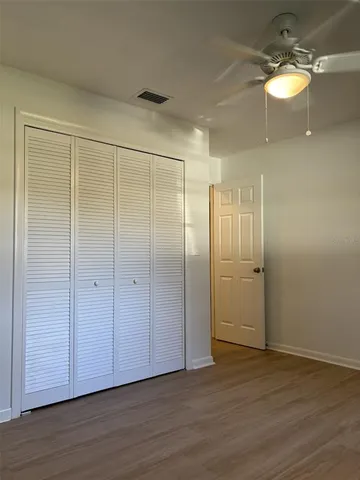 a view of a room with wooden floor and fan