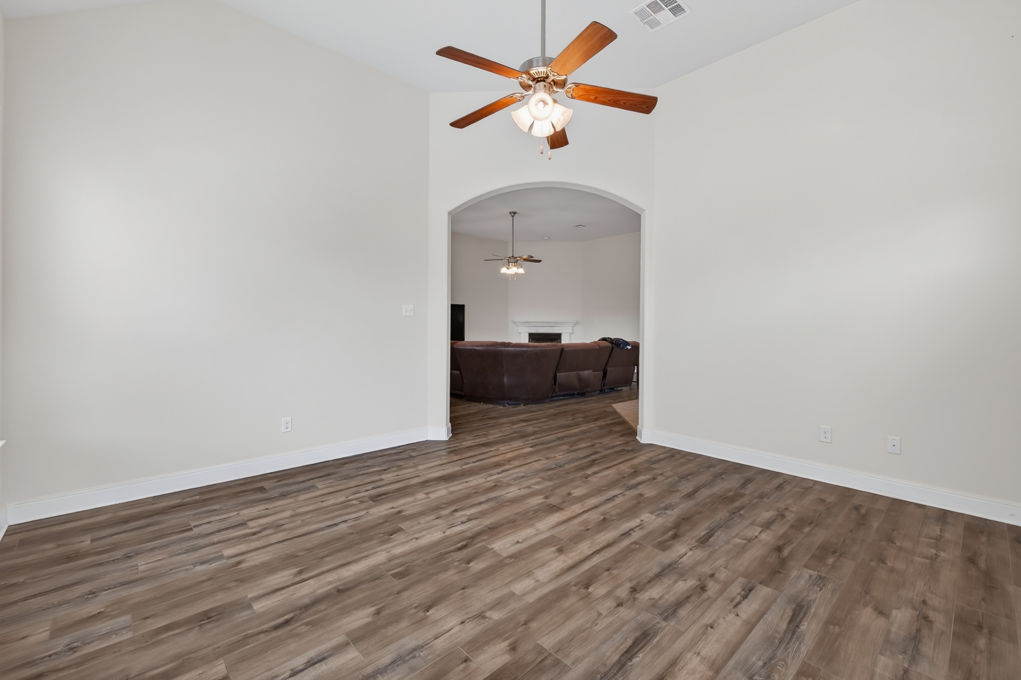 1017 Tabernash Leander, TX 78641 - Photo 32 of 38 Vaulted ceiling room featuring wood-finish flooring, a ceiling fan with light, and an arched doorway