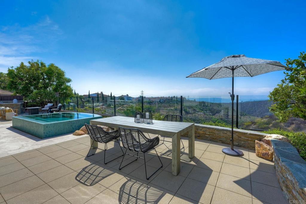 7127 Sitio Caliente Carlsbad, CA 92009 - Photo 19 of 24 a view of a tables and chairs under an umbrella