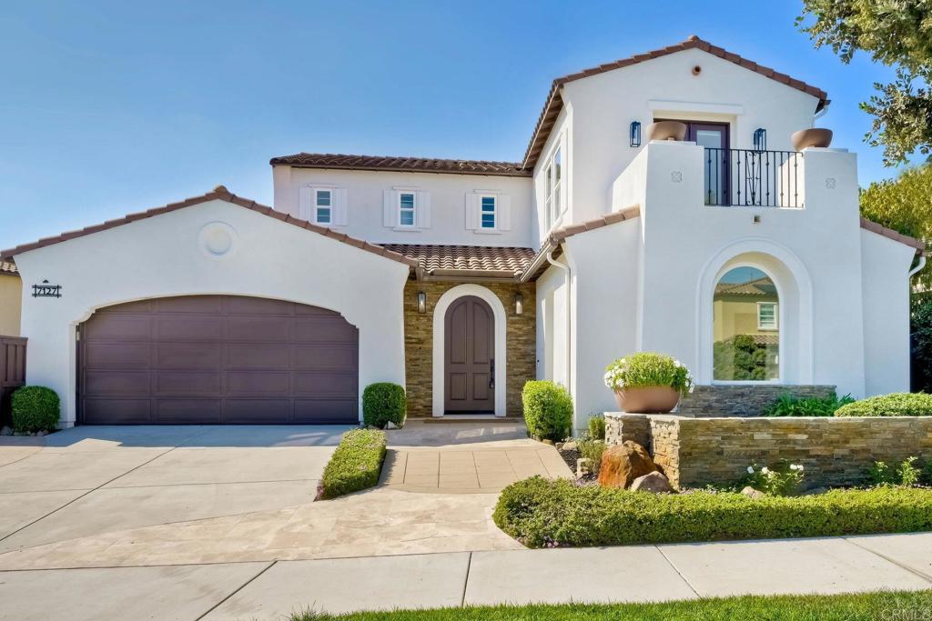 7127 Sitio Caliente Carlsbad, CA 92009 - Photo 3 of 24 a front view of a house with garden
