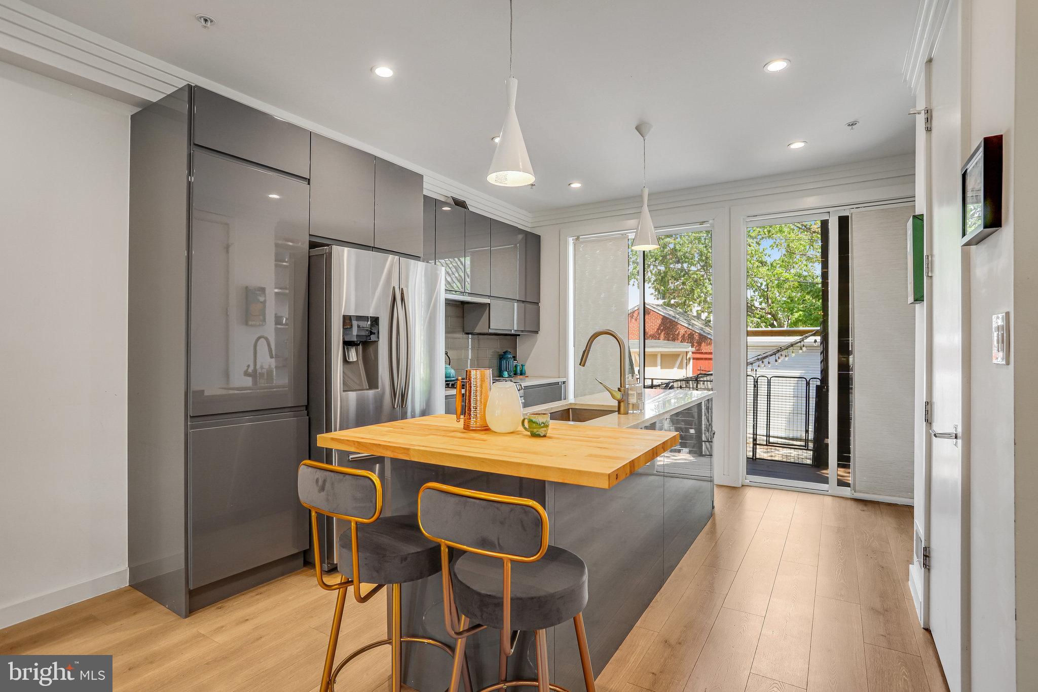 308 U Street Northeast, Unit 1 Washington, DC 20002 - Photo 9 of 25 a dining table with stainless steel appliances granite countertop a refrigerator a sink dishwasher a dining table and chairs with wooden floor