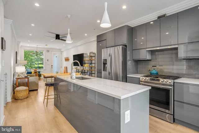 a kitchen with sink a refrigerator and chairs