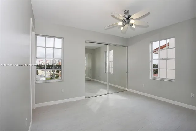 a view of an empty room with window and cabinet