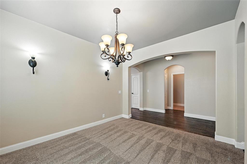 4203 Magnolia Road Melissa, TX 75454 - Photo 4 of 20 Empty room featuring dark carpet, hanging lights, and arched walkways