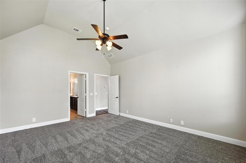 4203 Magnolia Road Melissa, TX 75454 - Photo 7 of 20 Unfurnished bedroom featuring dark carpet, connected bathroom, a ceiling fan, and a high ceiling