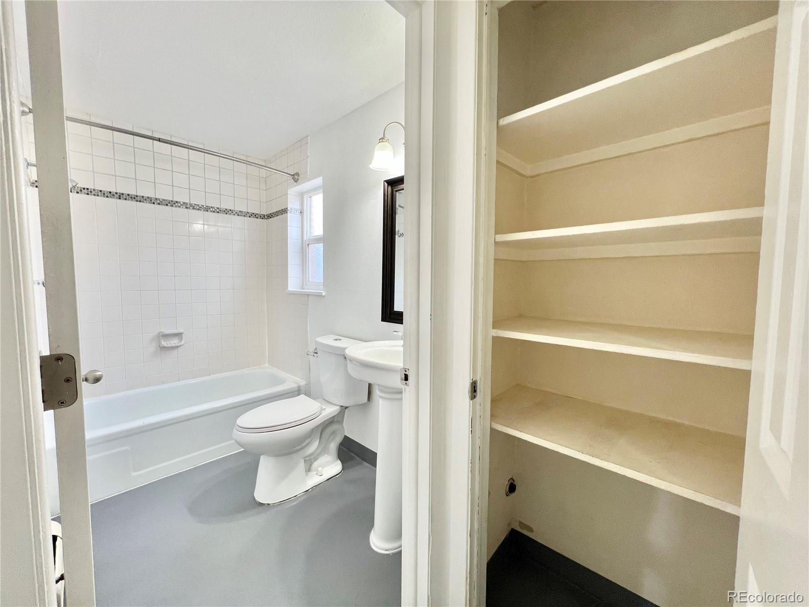 1090 South Eliot Street, Unit 102 Denver, CO 80219 - Photo 11 of 12 a bathroom with a toilet a sink and a shower