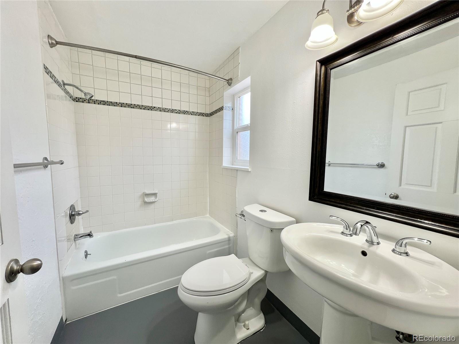 1090 South Eliot Street, Unit 102 Denver, CO 80219 - Photo 12 of 12 a bathroom with a sink toilet and shower