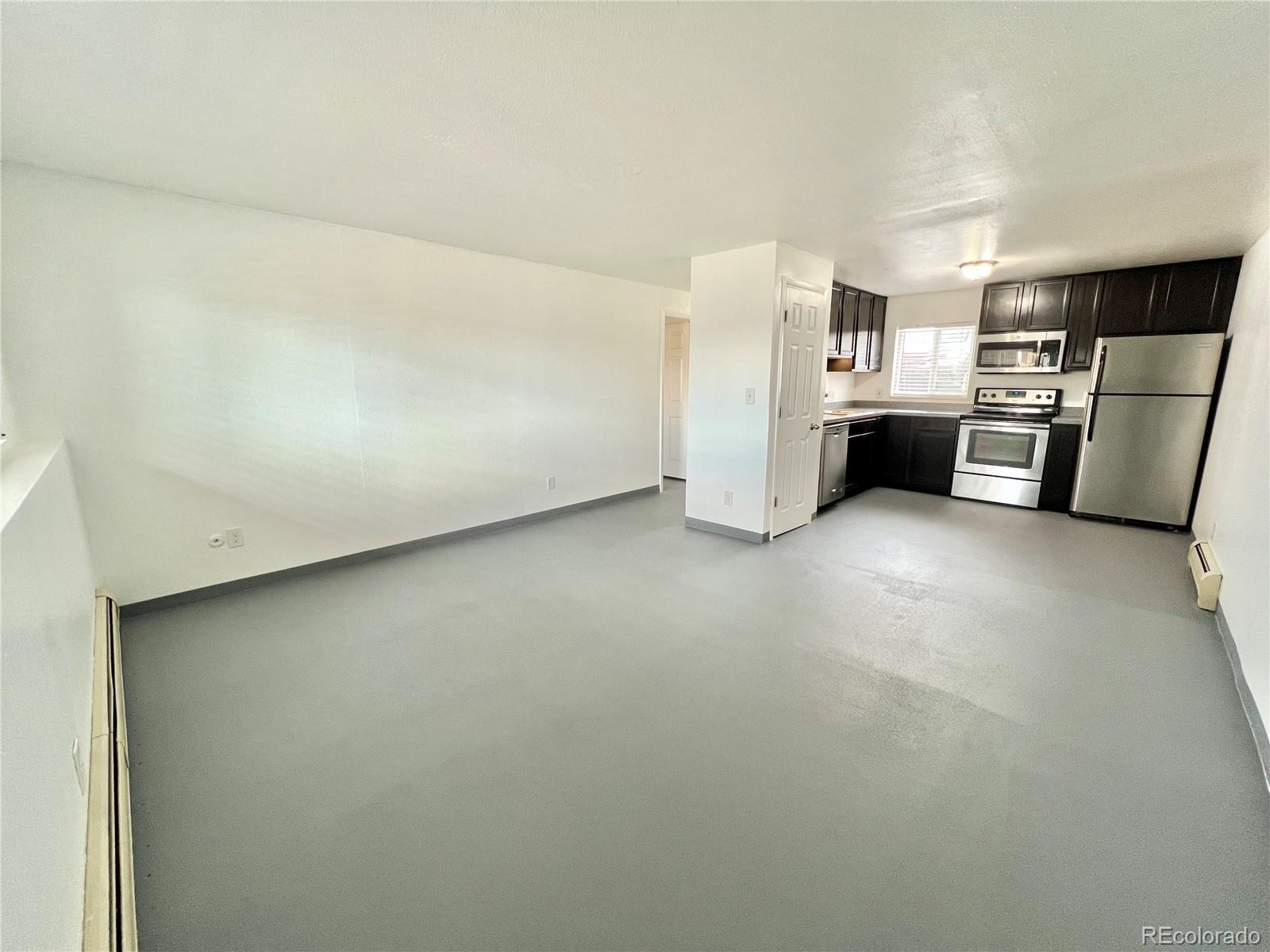 1090 South Eliot Street, Unit 102 Denver, CO 80219 - Photo 6 of 12 a view of a kitchen with refrigerator and a stove