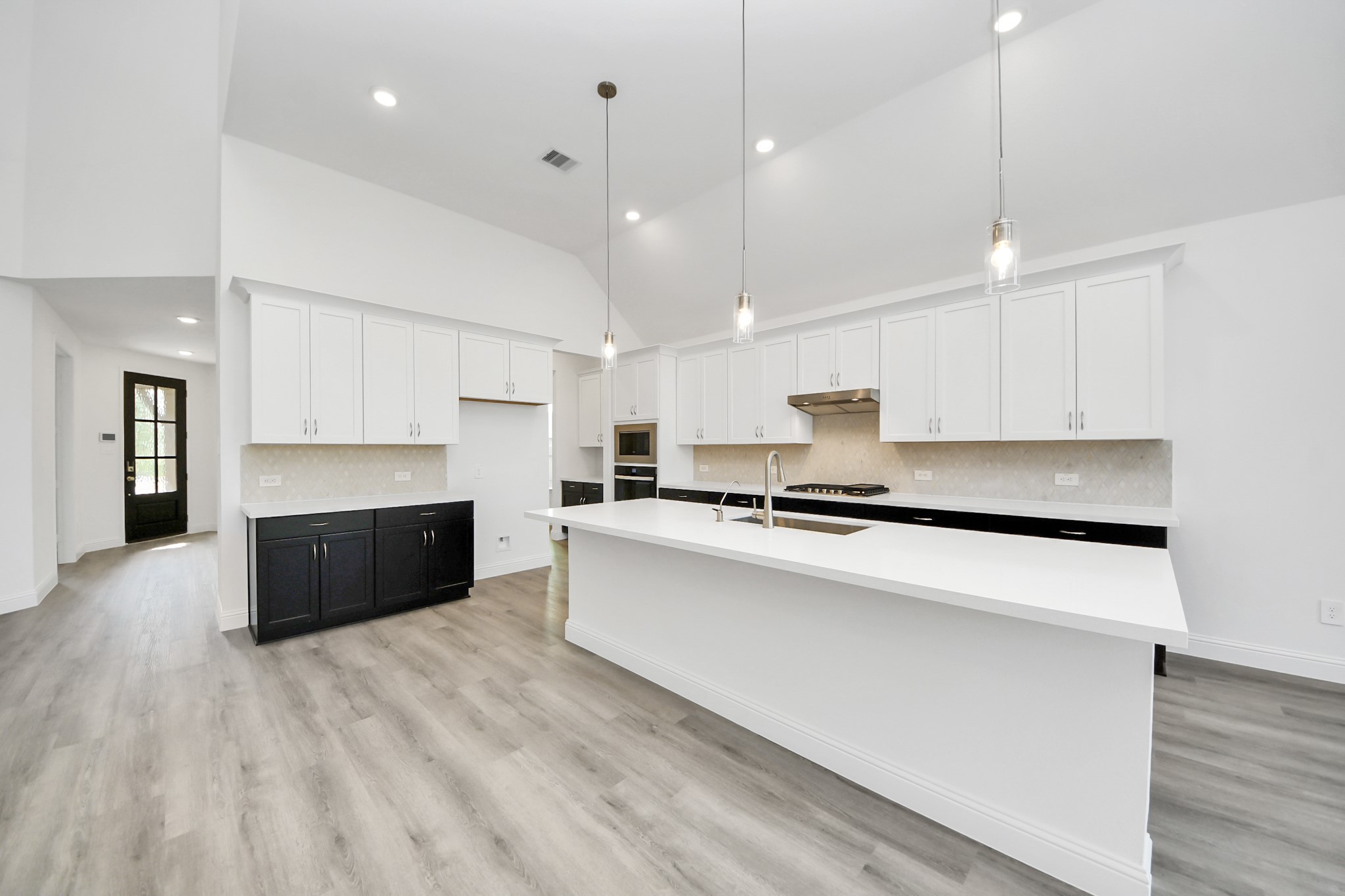 17315 July Moon Lane Conroe, TX 77302 - Photo 29 of 50 a large kitchen with stainless steel appliances kitchen island a stove a refrigerator a sink dishwasher and a stove with wooden floor
