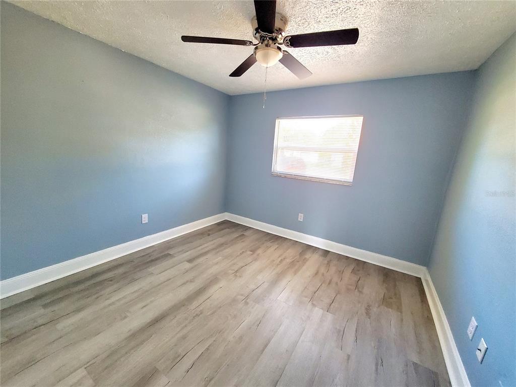 5838 Sun Glo Avenue Port Richey, FL 34668 - Photo 13 of 19 an empty room with a window and a ceiling fan
