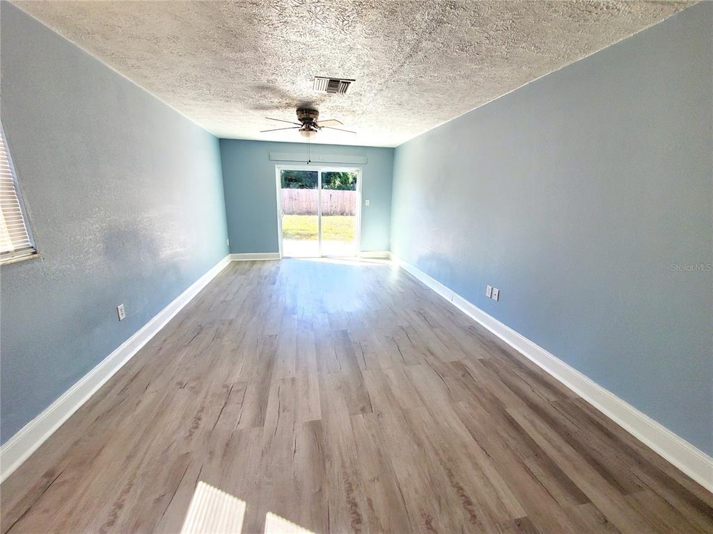 5838 Sun Glo Avenue Port Richey, FL 34668 - Photo 4 of 19 wooden floor in an empty room with a window