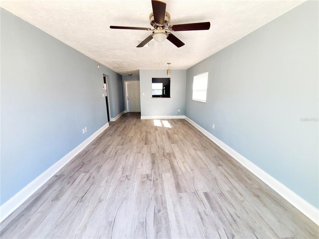 5838 Sun Glo Avenue Port Richey, FL 34668 - Photo 5 of 19 a view of empty room with wooden floor and fan