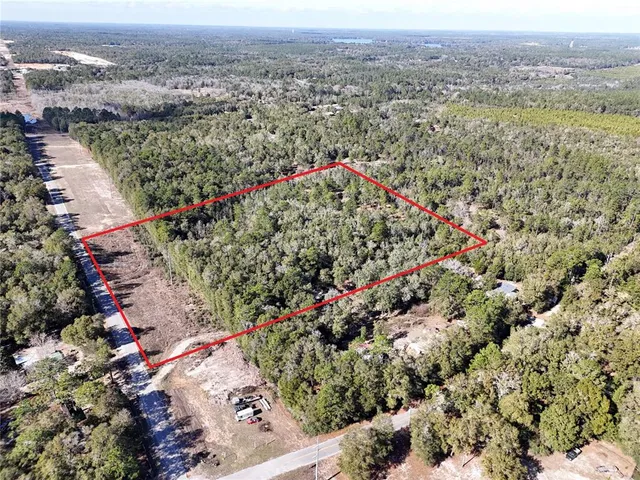 an aerial view of a houses with a lush green hillside
