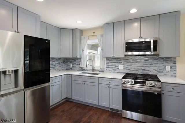 a kitchen with stainless steel appliances a stove a sink and a microwave